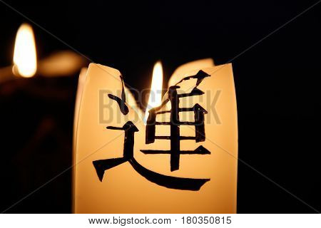 Burning candle with a hieroglyph in the dark