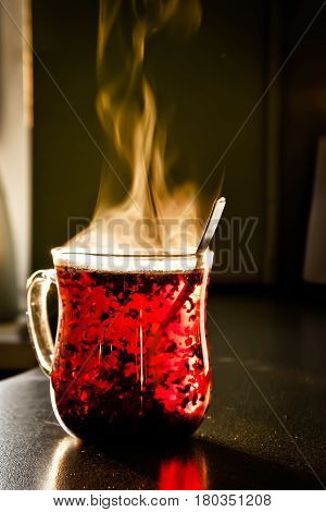 A cup of hot red tea is on the table