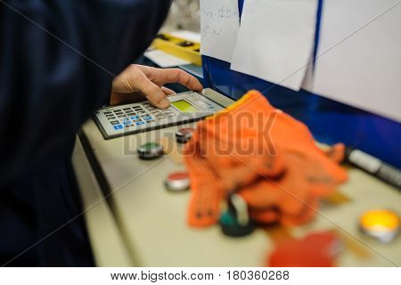 close up operator hand at metal roof forming machine