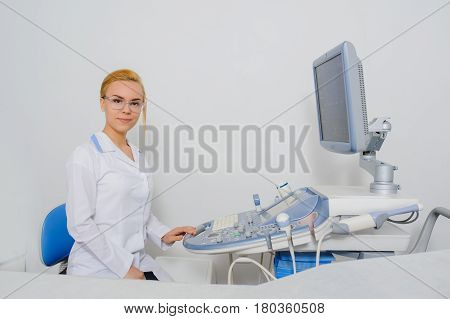 portrait of young beautiful woman doctor working at ultrasound diagnostic machine usg.