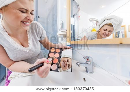 Woman In Bathroom Applying Contour Bronzer On Brush