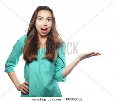 Young smiling woman points a hand with positive facial expressio