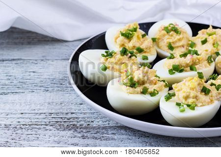 Home eggs stuffed with cheese and crab sticks topped with green onions