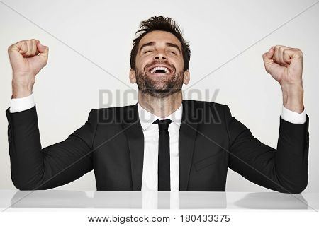 Joyful businessman punching air for succes studio shot