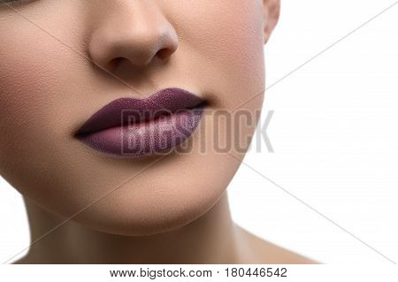 Close up shot of a beautiful smile of a woman with full sexy lips covered with purple lipstick isolated copyspace beauty fashion skin unblemished augmentation fillers cosmetology makeup visage .