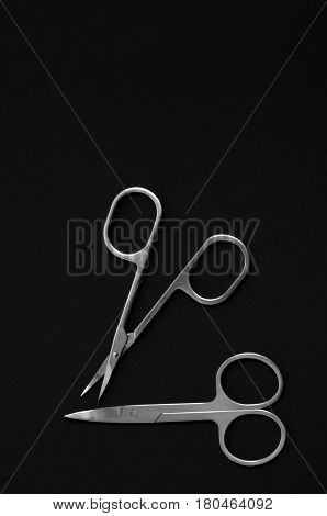 Scissors for manicure woman nails on a black background. tools.