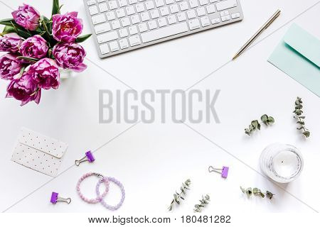 Spring pink flowers on workdesk at home ofiice white background top view mockup