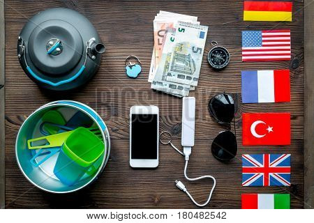 traveller lifestyle items with compass and plactic dishes on wooden table background top view