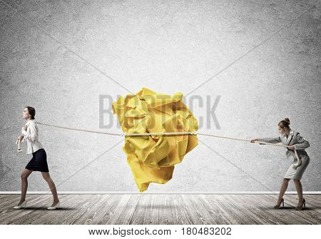 Two businesswomen playing tag of war game