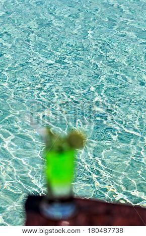 Glass of the soft drink is on a beach table (Maldives The Indian Ocean)