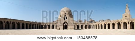 Panorama of the courtyard of Ibn Tulun Mosque Cairo Egypt featuring the ablution fountain and the minaret. The largest one in Cairo and the oldest one in the city with its original form