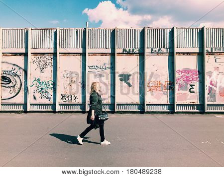 Kiev, Ukraine - April 04, 2017: Pedestrian goes Graffiti wall background. Urban street