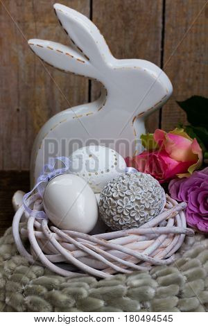 Easter eggs hunt - Bunny with nest of white eggs and roses
