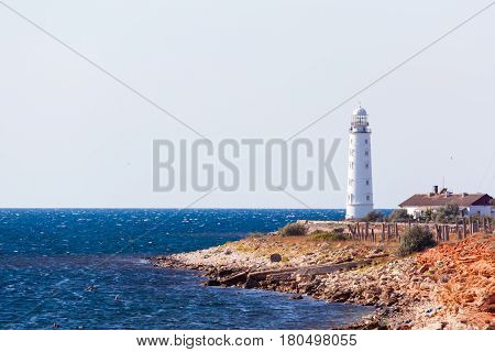 white lighthouse Hersones and road on the background of the sea in summer