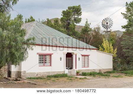 NIEU BETHESDA SOUTH AFRICA - MARCH 21 2017: A house with a water-pumping windmill in Nieu-Bethesda an historic village in the Eastern Cape Province