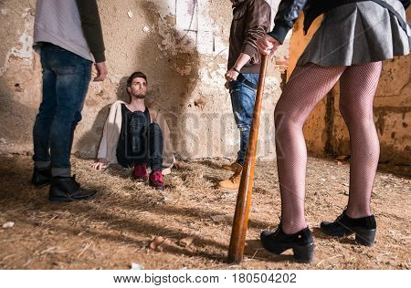 Scared boy surrounded by homophobic people in abandoned house