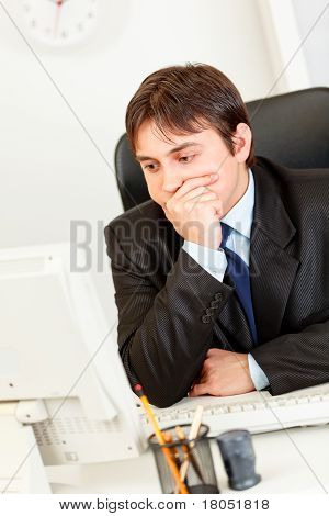 사무실 책상에 앉아서 컴퓨터 모니터를 보면서 생각에 잠겨있는 현대 사업
