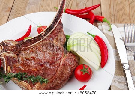 cibo di carne: manzo alla griglia di ricambio rib su piatto bianco con pepe timo e pomodoro sul tavolo di legno