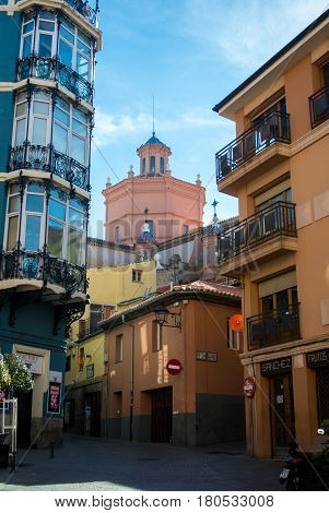TERUEL SPAIN - FEBRUARY 01 2016: A narrow street with old houses in different styles and a cathedral at the background at medieval town Teruel at Aragon province Spain.