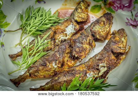 Fried fish with sambal belacan and vegetable side dish.Fried fish with sambal is a popular home-style dish in Malaysia,Singapore,Indonesia & Thailand.