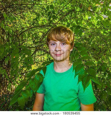 Cute Smart Boy In The Garden Under The  Tree