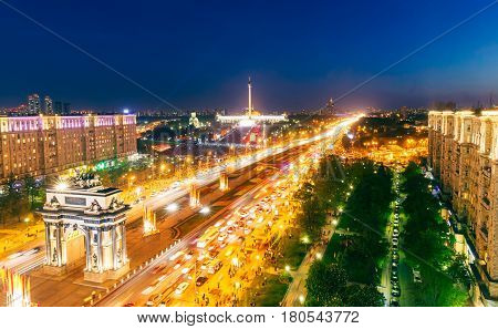 Triumphal Arch, Victory Park and the alley of fountains in Moscow, blurry lights of cars on multi-lane highways and road junction at night in Moscow