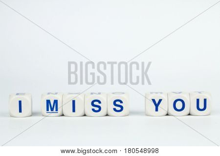 Blue Alphabet on White Cube Blocks say I MISS YOU in White Background with Shadow