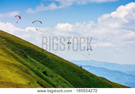 Skydivers fly over the mountains. Parachute extreme sport