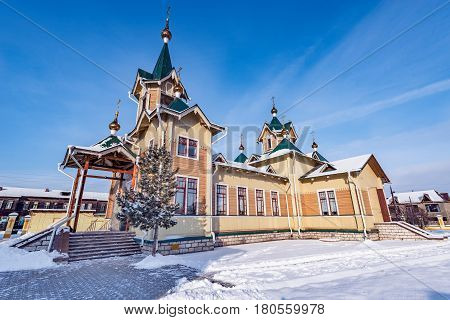 The wooden church of St. Nicholas at winter day time. Church was founded at the beginning of the 20th century. Slyudyanka. Russia.