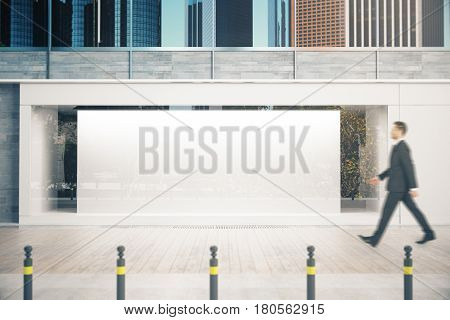 Man Passing Shopfront With Banner