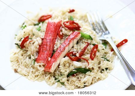 Talíř rýže restované s crabsticks a zelené fazolky, vidličkou na straně, izolovaných na bílém