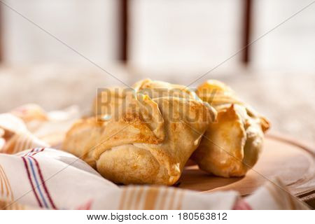Pies in peasant style on a wooden rustic table. Morning light. Selective focus.