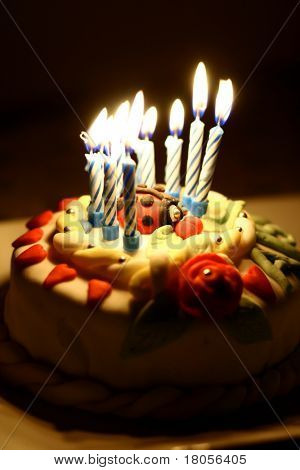 Close up of a birthday cake all lit up in the dark