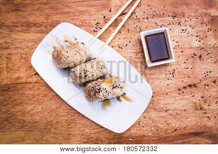 Sushi Onigiri with tuna and soy sauce on a white plate