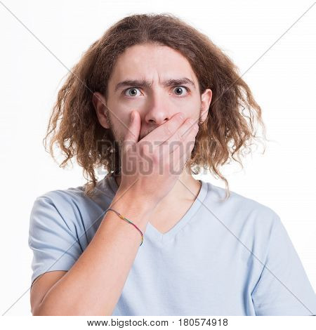 Keep silence. Gossip concept. Surprised man covering mouth with hand on white isolated studio background