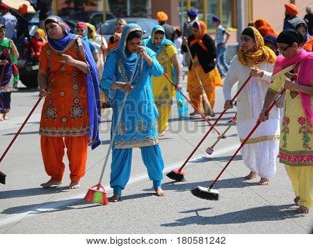 Vicenza, Vi, Italy - April 8, 2017: Women Sikh Religious Ceremony Sweep The Street With Brooms Durin