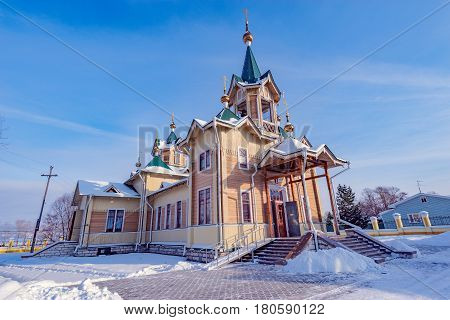 The wooden church of St. Nicholas at winter day time. Church was founded at the beginning of the 20th century. Slyudyanka. Russia.