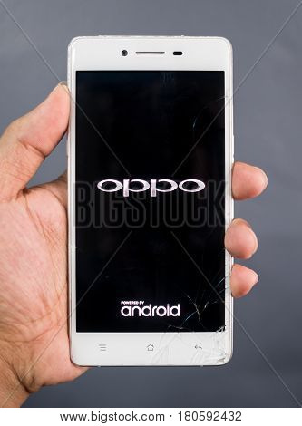 Chiangrai Thailand: March 02 2017 - Human hand holding broken Oppo R7 smartphone and showing logo 'Oppo Android' on screen