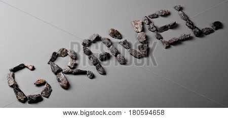 Letters From Gravel On Gray Background. Wrote Gravel.copy Space