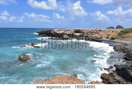 Aruba's black sand beach with tropical waters just off shore.