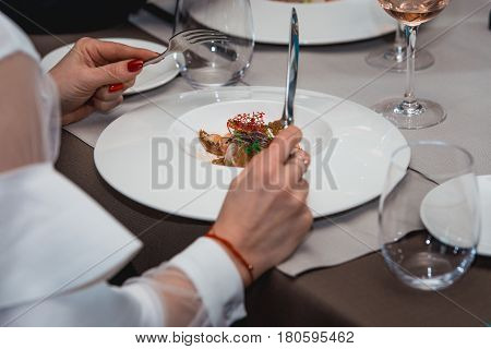 woman is preparing to eat delicious salmon salad in a restaurant. small portion.