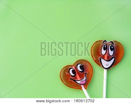 Two lollipops on green background. Love concept