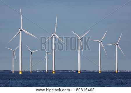 Offshore farm windturbines near Dutch coast against blue sky