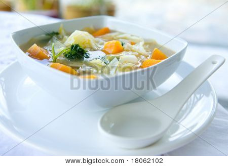 Uma tigela de sopa de repolho e batata doce saudável com salsa.