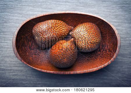 Salak or snake fruit in a wooden textured plate, exotic plants