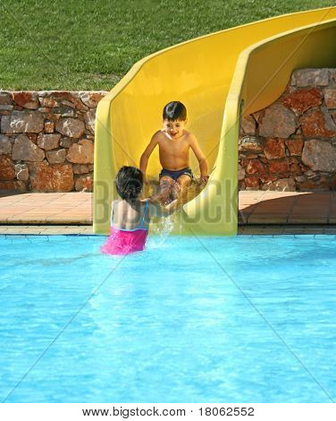 Junge Hilfe von seiner Schwester, als er nach unten die Wasserrutsche im Freibad rutschte