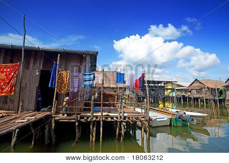 Vista di case in legno dal tetto di paglia in un villaggio di acque vicino Tuaran, Sabah Malaysia