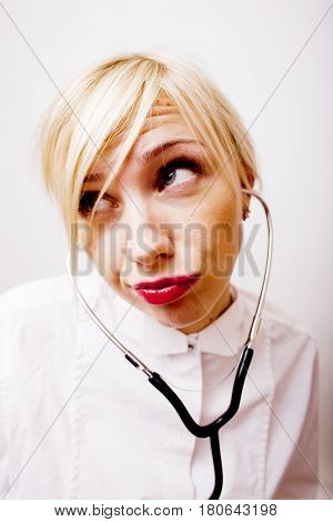 young pretty woman doctor with stethoscope emotional posing, pointing in camers, lifestyle people concept close up