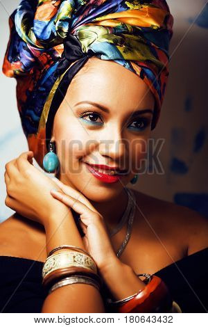 beauty bright real african woman with creative make up, shawl on head like cubian closeup smiling