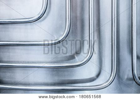 Thin steel tubes curved at right angles. Abstract industrial background.